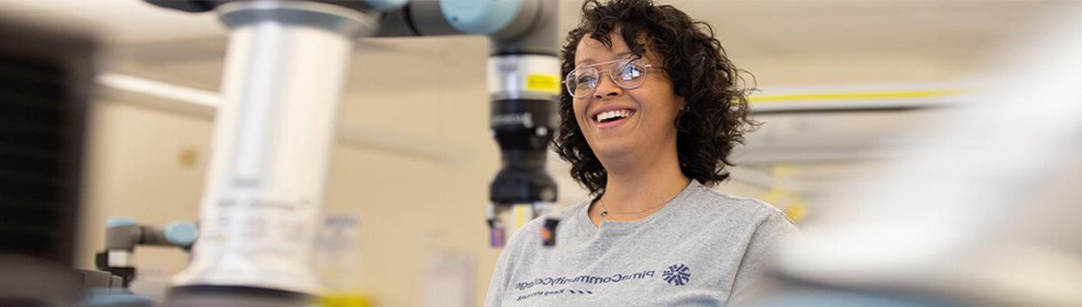 在皮马大学的AIT实验室里，一名学生在摆弄制造机器人时露出了微笑