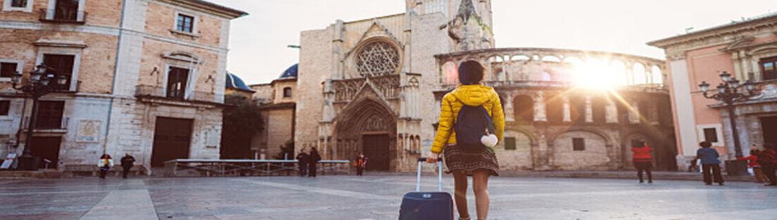 一个学生提着行李走近一座欧洲城